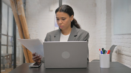 African American Businesswoman Working on Business Report with Laptop