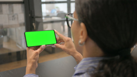 African Woman Holding Phone with Green Screenの写真素材