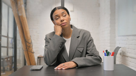 Sleeping African American Businesswoman Sitting in Officeの写真素材