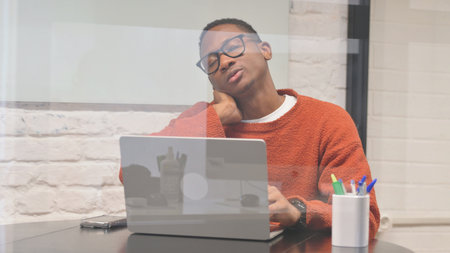 African Man having Neck Fatigue and Pain at Workspace
