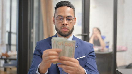 Portrait of Happy Hispanic Businessman Counting Moneyの写真素材
