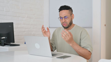 Hispanic Man with Loss on Laptopの写真素材