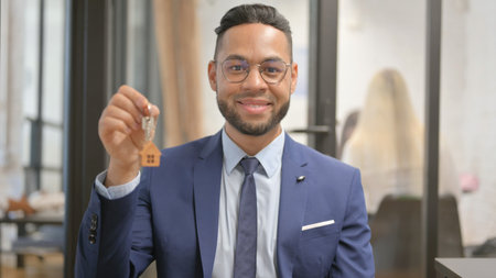 Portrait of Happy Hispanic Businessman Showing Home Keys