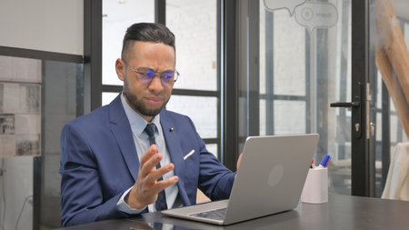 Middle Aged Businessman Shocked by Loss on Laptopの写真素材