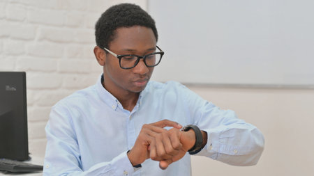 Portrait of Young African Man Using Smart Watch