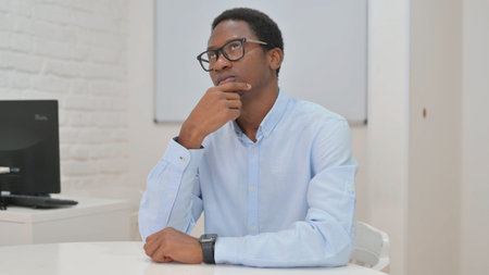 Pensive Young African Businessman Brainstorming for Projectの写真素材
