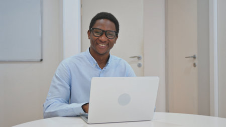 Smiling African American Businessman Looking at Camera at Workspace