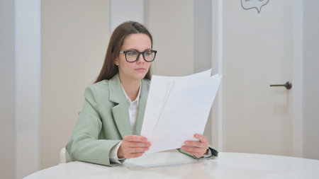 Young Woman Reading Documents at Work