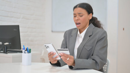 African Business Woman Reacting to Online Shopping Failure with Smartphoneの写真素材