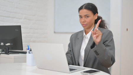 African Business Woman in Denial Looking at Camera While Working on Laptopの写真素材