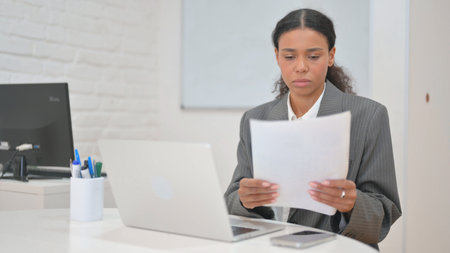 African Business Woman Working on Documents and Laptop