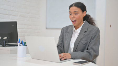 African Business Woman Celebrating Success on Laptop
