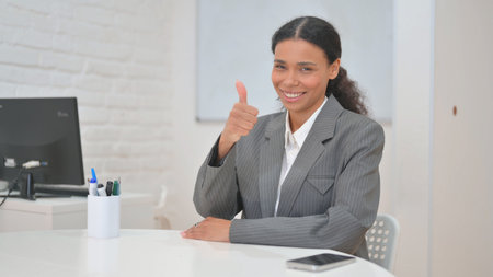 Thumbs Up by African Business Woman while Sitting in Office