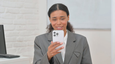 Portrait of African Business Woman Doing Video Chat on Phoneの写真素材