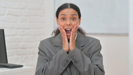 Portrait of Surprised African Business Woman Enjoying Winの写真素材