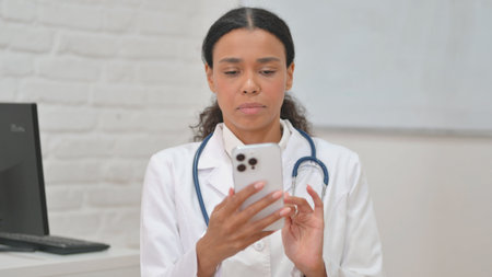 Portrait of African Female Doctor Using Smartphoneの写真素材