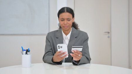 African Business Woman Reacting to Online Shopping Failure with Smartphoneの写真素材
