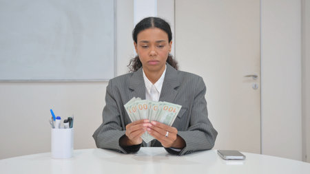 African Business Woman Counting Money in Office