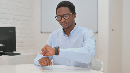 Waiting Young African Businessman Checking Timeの写真素材