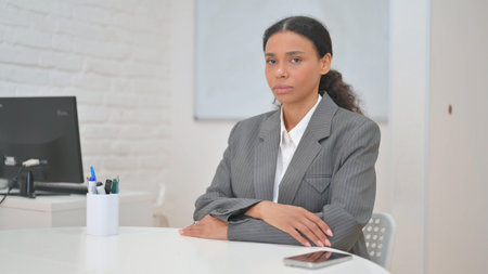 African Business Woman Looking at Camera while Sitting in Officeの写真素材