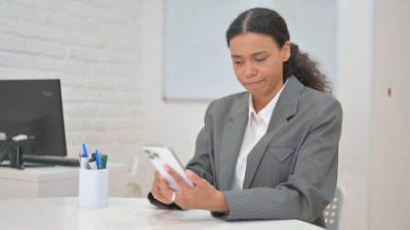 African Business Woman with Trading Loss on Phoneの写真素材