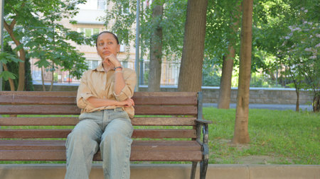 Multi Ethnic Woman Pondering on a Park Benchの写真素材