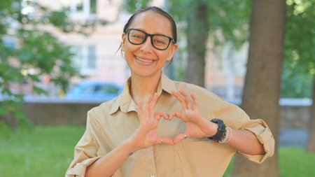 Multi Ethnic Woman Making a Heart Gesture Outdoors