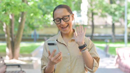 Talking Multi Ethnic Woman Doing a Video Call Outdoorsの写真素材