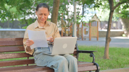Young Woman Expressing Frustration While Working Outdoorsの写真素材