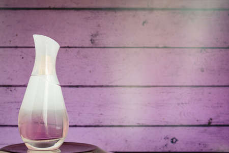 Women's perfume in a beautiful bottle on a pink wooden background.の写真素材
