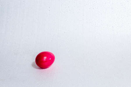 Single red colored egg, symbol of Easter. On white background.の写真素材