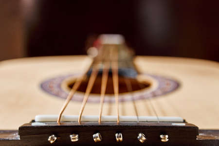 Classical guitar on a dark background with blurred bokeh effect.の写真素材