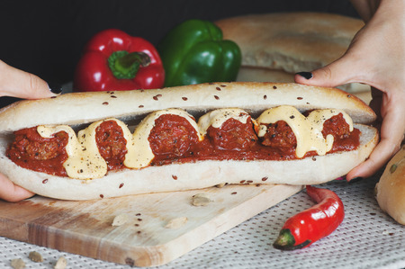 Young girl holding in female hands fast food sandwich with meatballsの写真素材