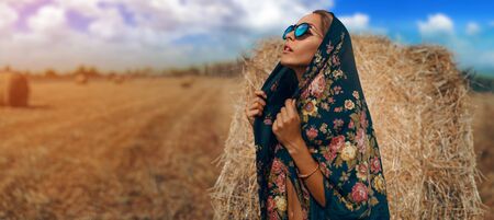Woman standing in black russian shawl In Harvested Fieldの写真素材