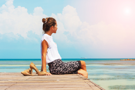 Young woman sitting on wooden bridge. Lady freelancer relaxingの写真素材