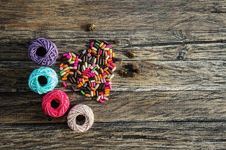 colorful yarn and beads in the shape of heart on wooden backgroundの写真素材