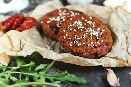 Potato burgers on baking paper on dark grey table. Still life of cooked batat burgers. Vegan food. Top viewの写真素材