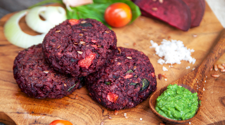 Vegan burgers with beetroot and beans served with fresh vegetablesの写真素材