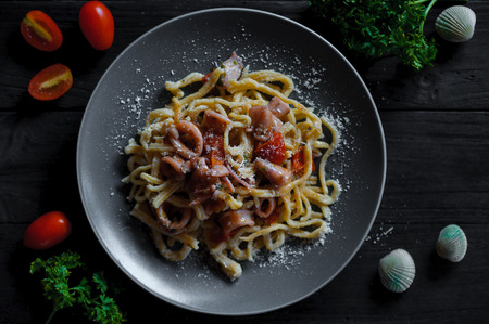Spaghetti seafood in grey plate on black wood tableの写真素材