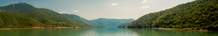 Scenic view on lake in Georgia mountains. Clouds reflect in water, panoramic viewの写真素材