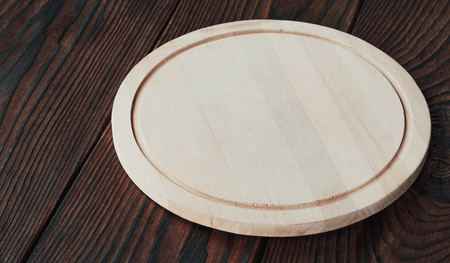 Background for product montage. empty round wooden board for cutting on a wooden backgroundの写真素材