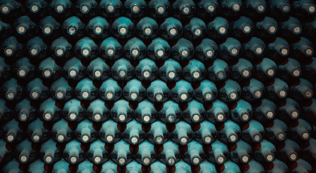 stacked up dusty wine bottles in the cellarの写真素材
