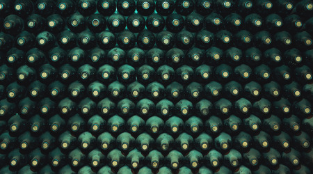 stacked up dusty wine bottles in the cellarの写真素材