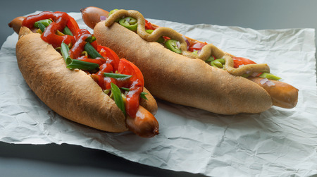 Two Tasty hot dogs on paper on grey backgroundの写真素材