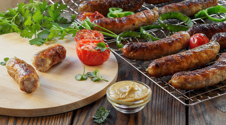 Grilled sausages and vegetables on a wooden background in rustic style. Top view. Flat lay.の写真素材