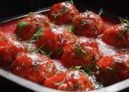 Meatballs with spicy tomato sauce in pan on wooden backgroundの写真素材