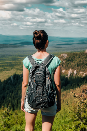 Woman Traveler with Backpack hiking in Mountains with beautiful landscapeの写真素材