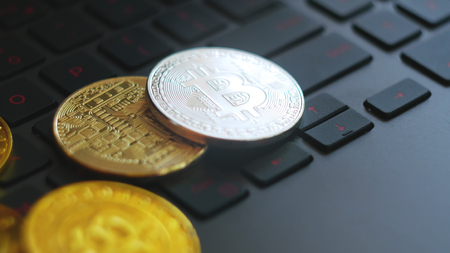 golden and silver bitcoins on keyboardの写真素材