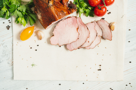 Traditional smoked meat with vegetables on wooden table, top viewの写真素材