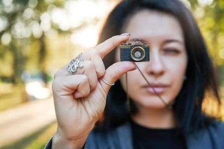 Woman photographer, taking pictures on her jewelry camera at sunsetの写真素材